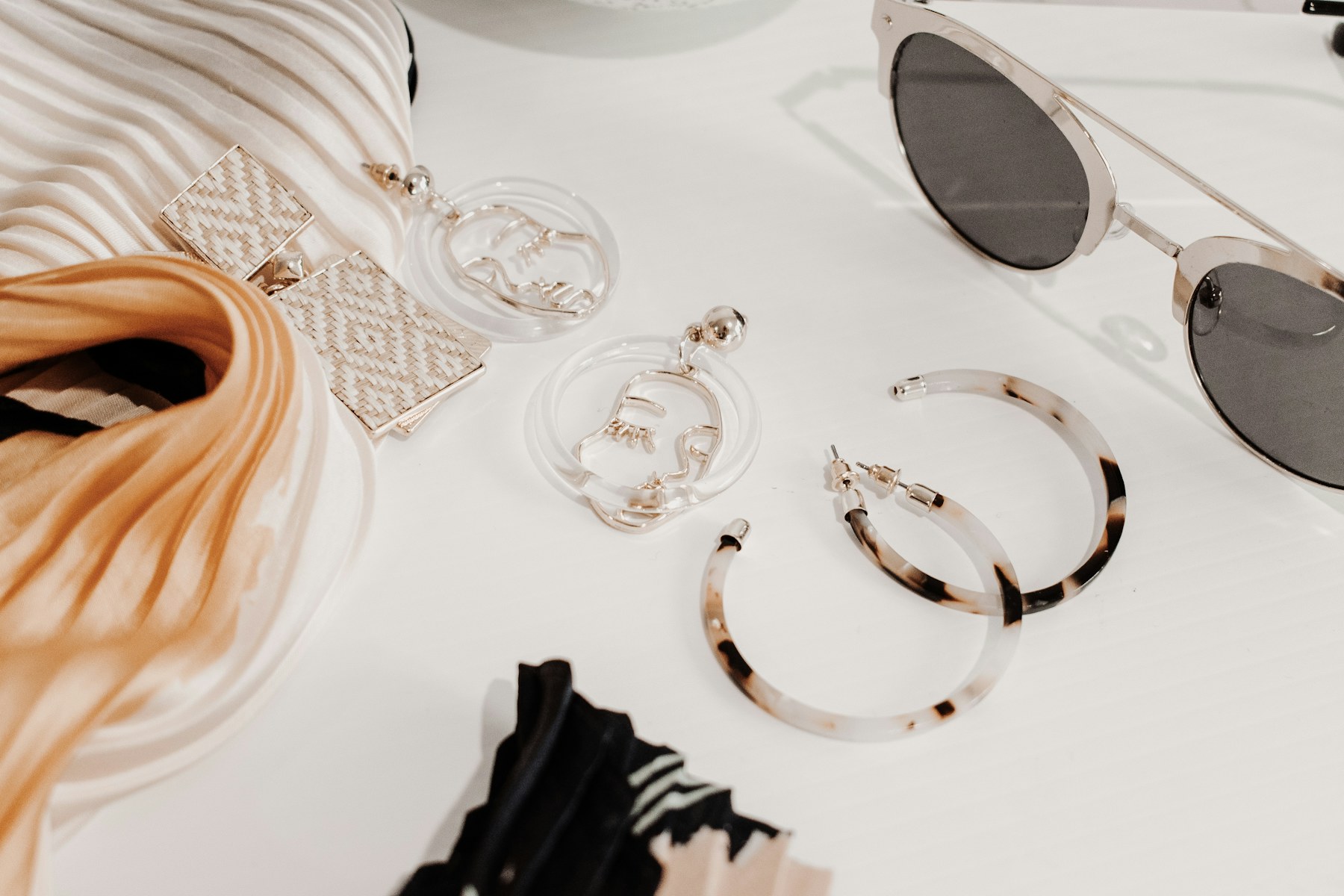 Warm-toned scarf, sunglasses, and small accessories.